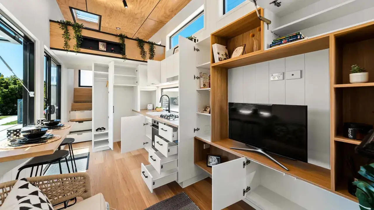 Ein gemütliches Tiny House mit offener Küche, Essbereich und viel Stauraum. Ein Beispiel für die Tiny House Movement.