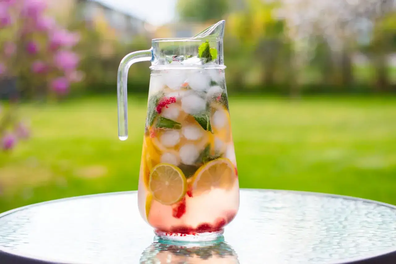 En karaff med is, citron, lime, mynta och hallon, perfekt f&ouml;r en svalkande sangria vit i tr&auml;dg&aring;rden.