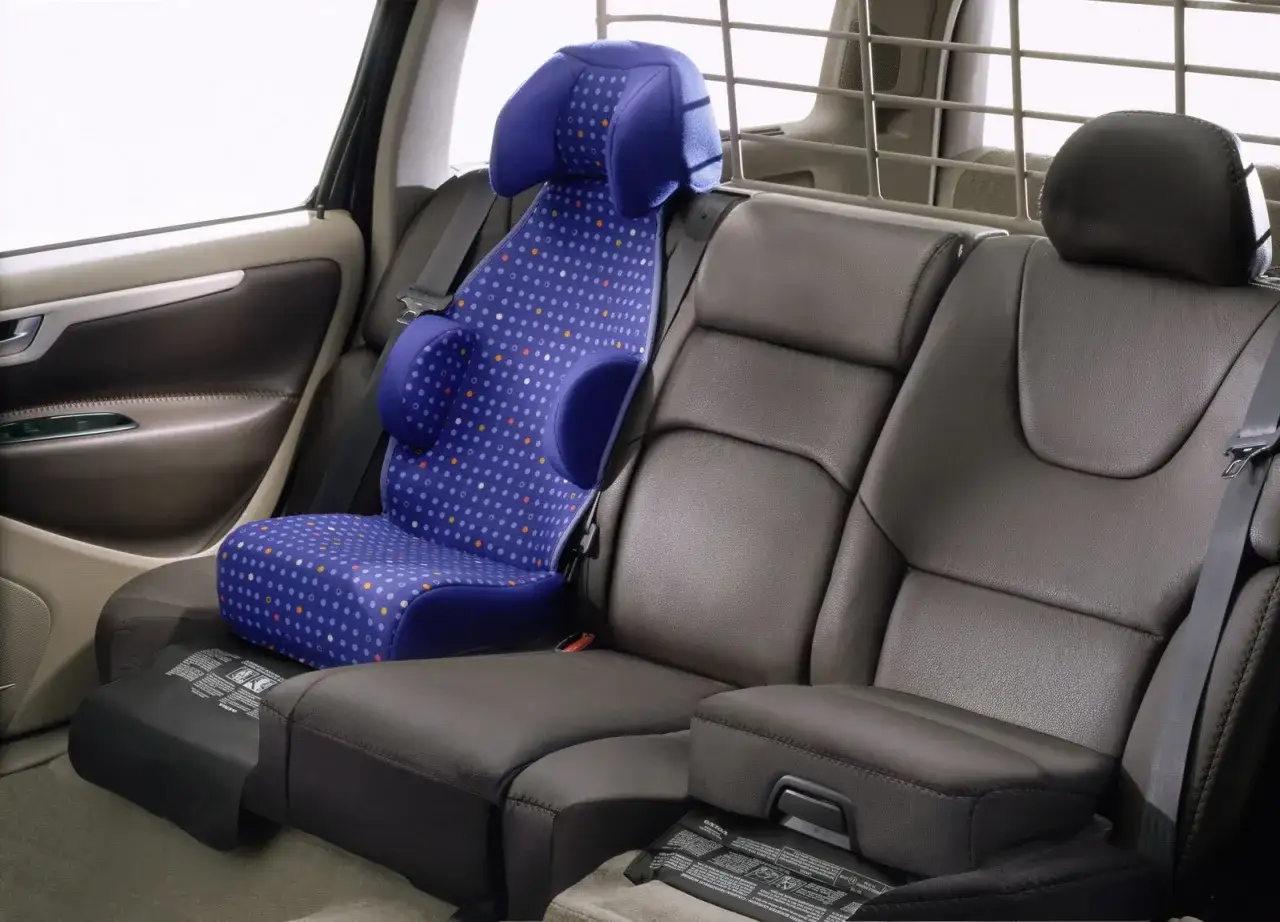 Seggiolino auto blu a pois su sedile posteriore in pelle. Il sistema isofix è obbligatorio per la sicurezza dei bambini in auto.