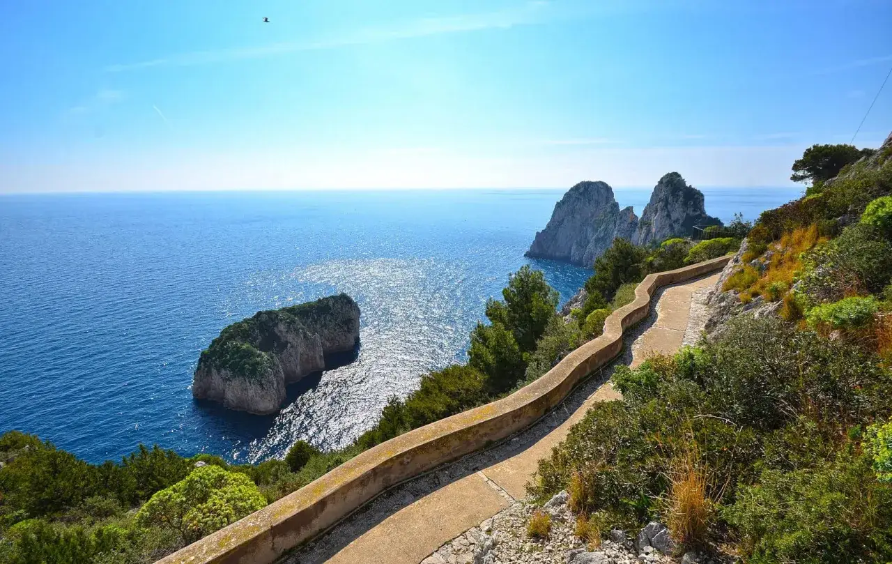 Sentiero panoramico a picco sul mare blu di Capri, con i Faraglioni sullo sfondo. Un luogo incantevole per passeggiare, magari verso il castiglione.
