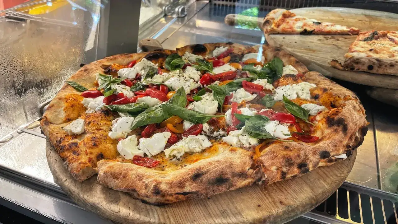 Pyszna pizza z pomidorkami, mozzarellą i bazylią. Idealna odpowiedź na pytanie