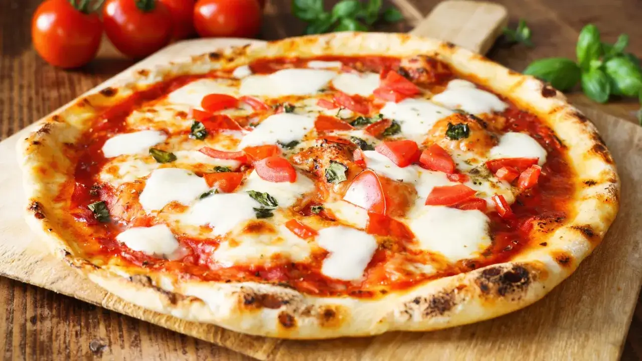 Pizza Margherita z pomidorami, bazylią i roztopionym serem fior di latte. Idealna na szybki lunch.