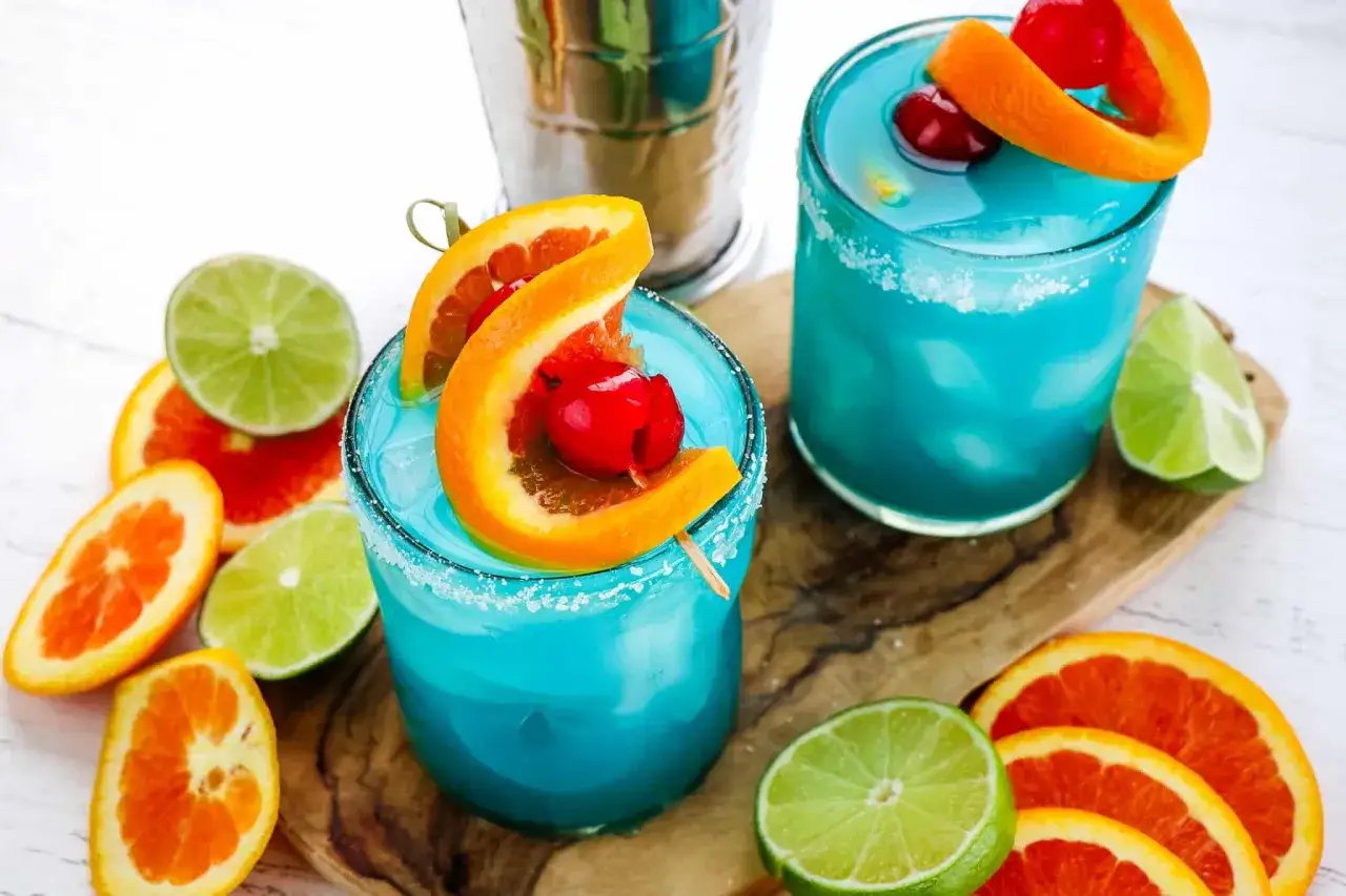Dwa błękitne drinki z wiśnią i pomarańczą, otoczone plasterkami cytrusów. Zastanawiasz się, ile kalorii ma drink?