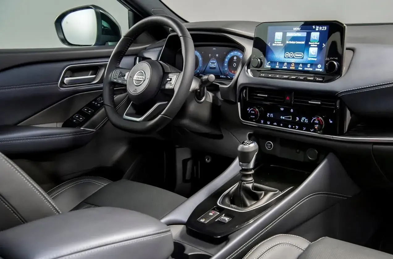 Wnętrze Nissan Qashqai 2022: skórzana tapicerka, cyfrowe zegary, dotykowy ekran multimediów i elegancka dźwignia zmiany biegów.