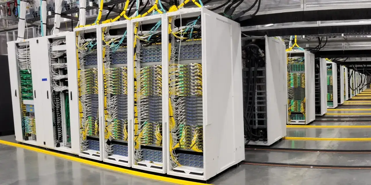 Rangées de serveurs dans un data center Microsoft, avec des câbles jaunes et blancs organisés.