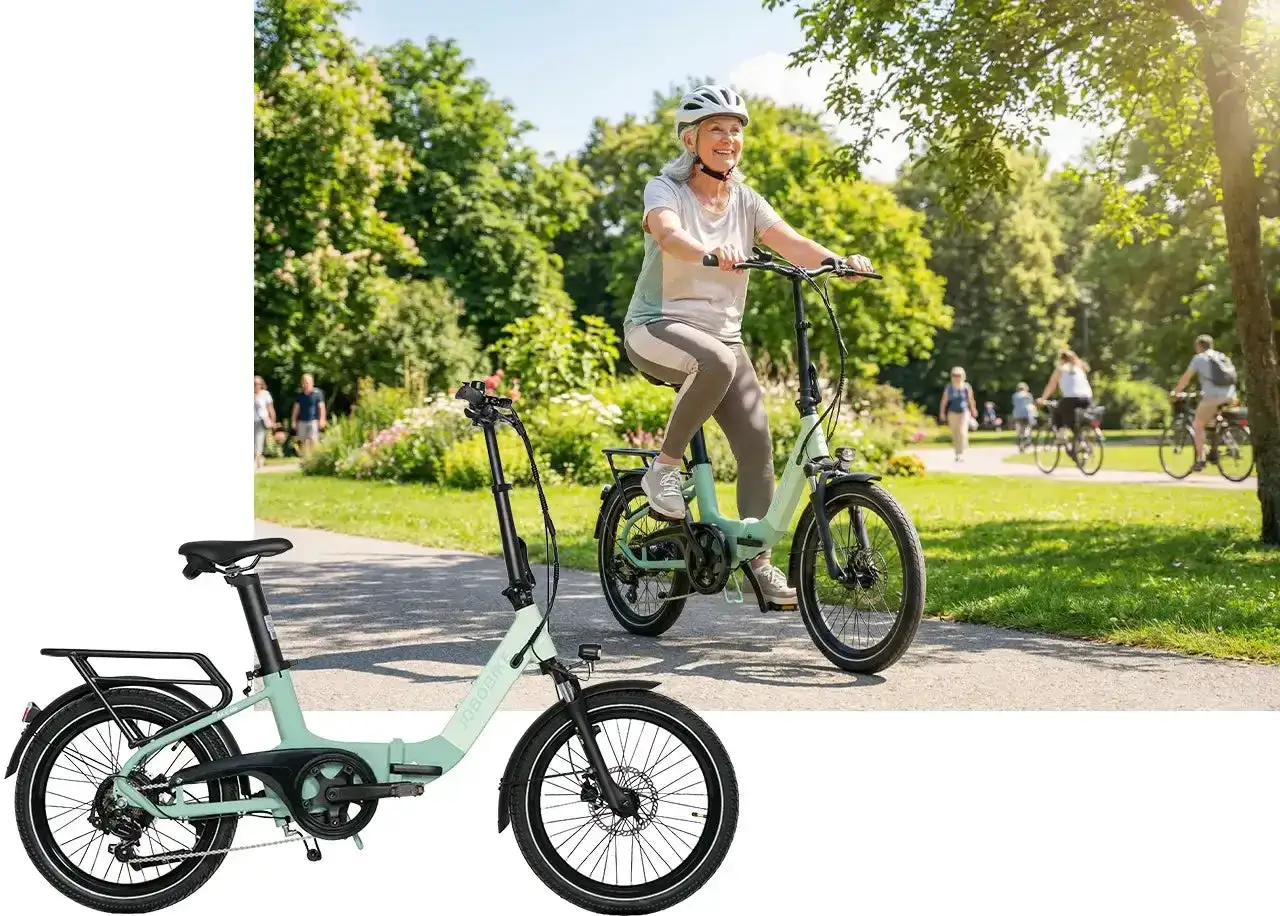 Uśmiechnięta seniorka na rowerze elektrycznym dla seniora w parku. Obok stoi złożony rower.