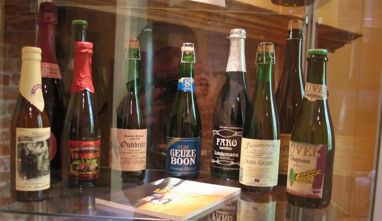 Bottiglie di birra Lambic, alcune con etichette che menzionano 