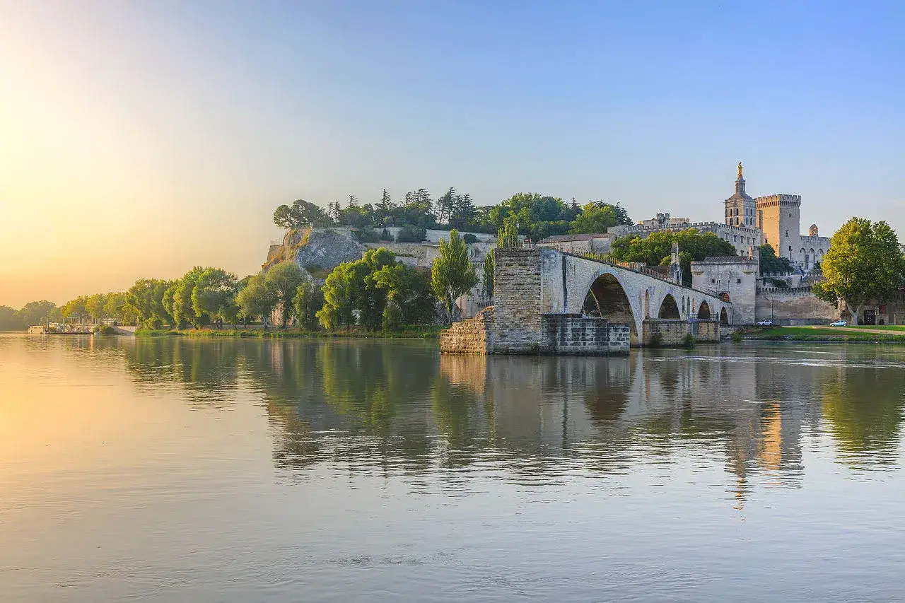Most Saint-Bénézet w Awinionie, odbijający się w spokojnej rzece Rodan o wschodzie słońca.