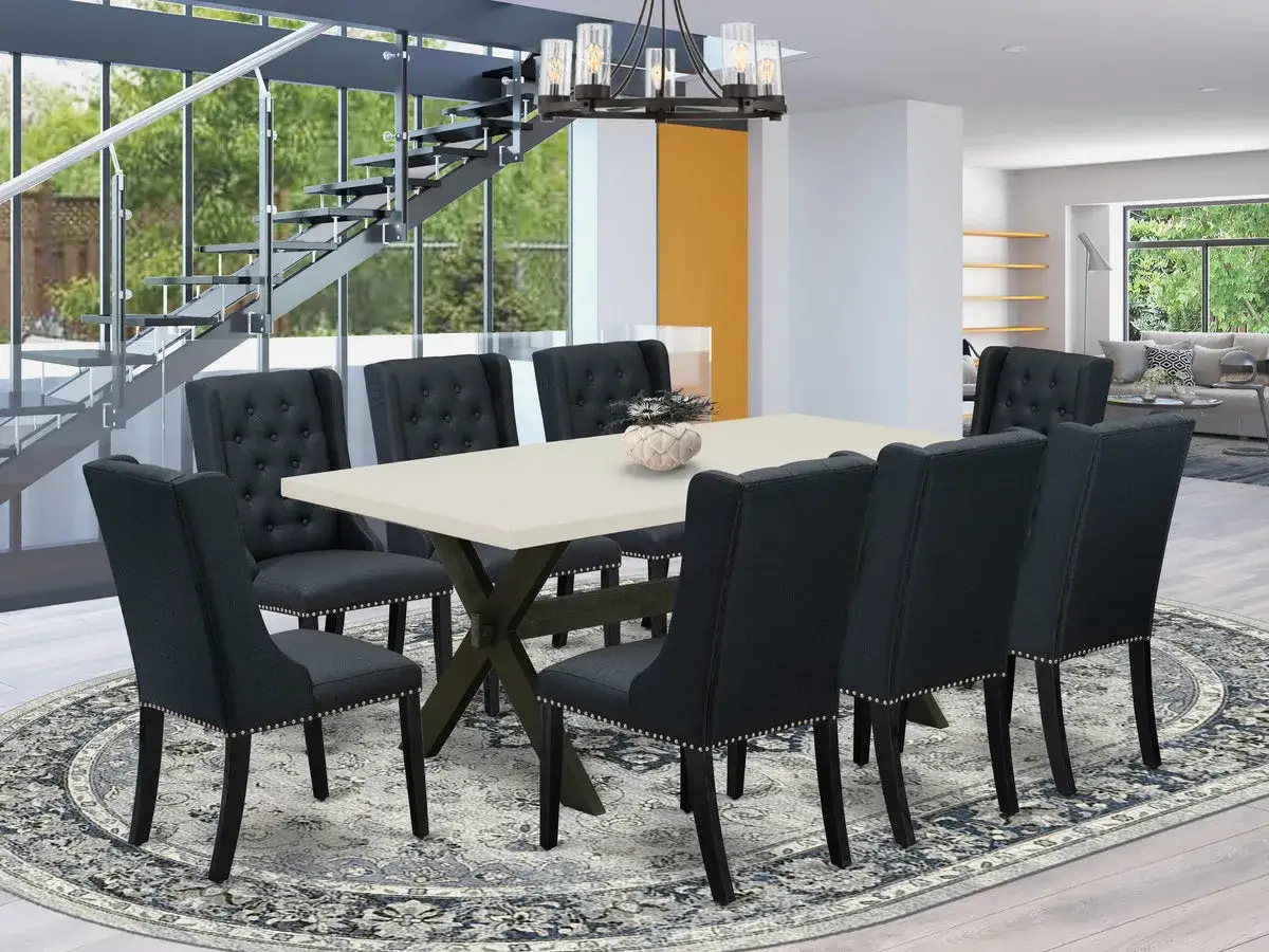 Comment assortir des chaises &agrave; une table : chaises sombres capitonn&eacute;es autour d'une table claire, dans un salon moderne avec escalier.
