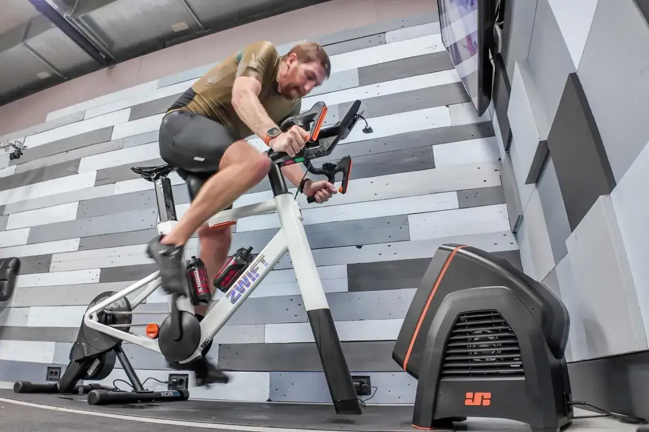 Man cycling indoors on a Zwift bike, getting started with his virtual ride.