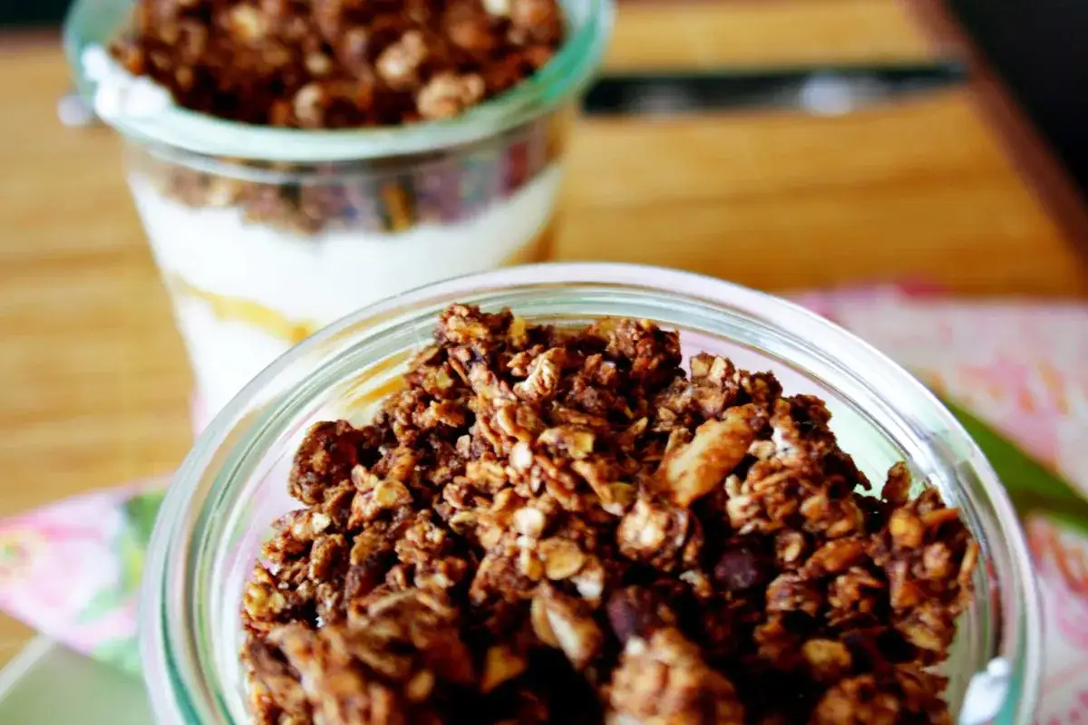 Knuspriges Schoko-Granola mit Apfelmus in Gläsern, bereit zum Genießen.