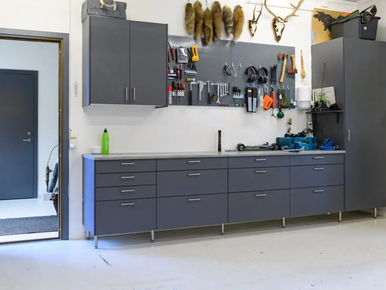 Snygga garage med gråa skåp och verktygstavla. Perfekt garage inspiration för ordning och reda.