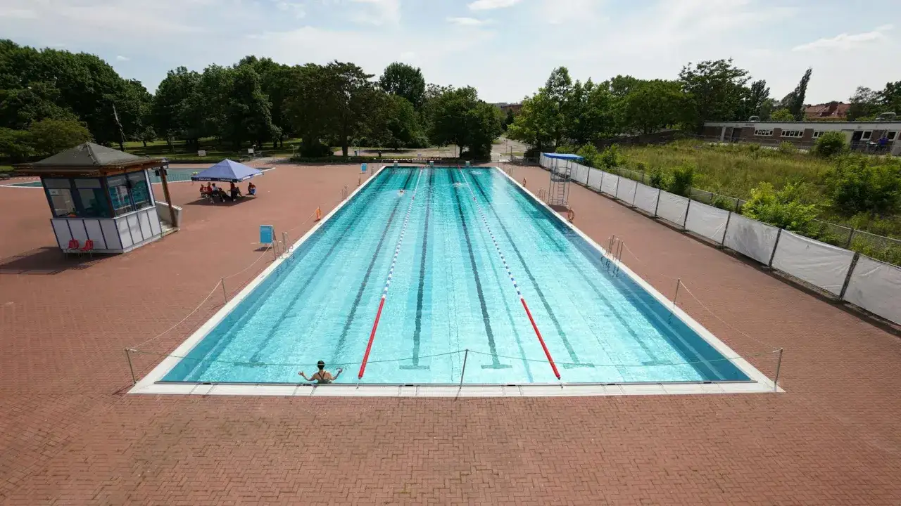 Ein Schwimmer genie&szlig;t das k&uuml;hle Wasser im Schwimmbad Pankow. Die Bahnen sind f&uuml;r Wettk&auml;mpfe vorbereitet.