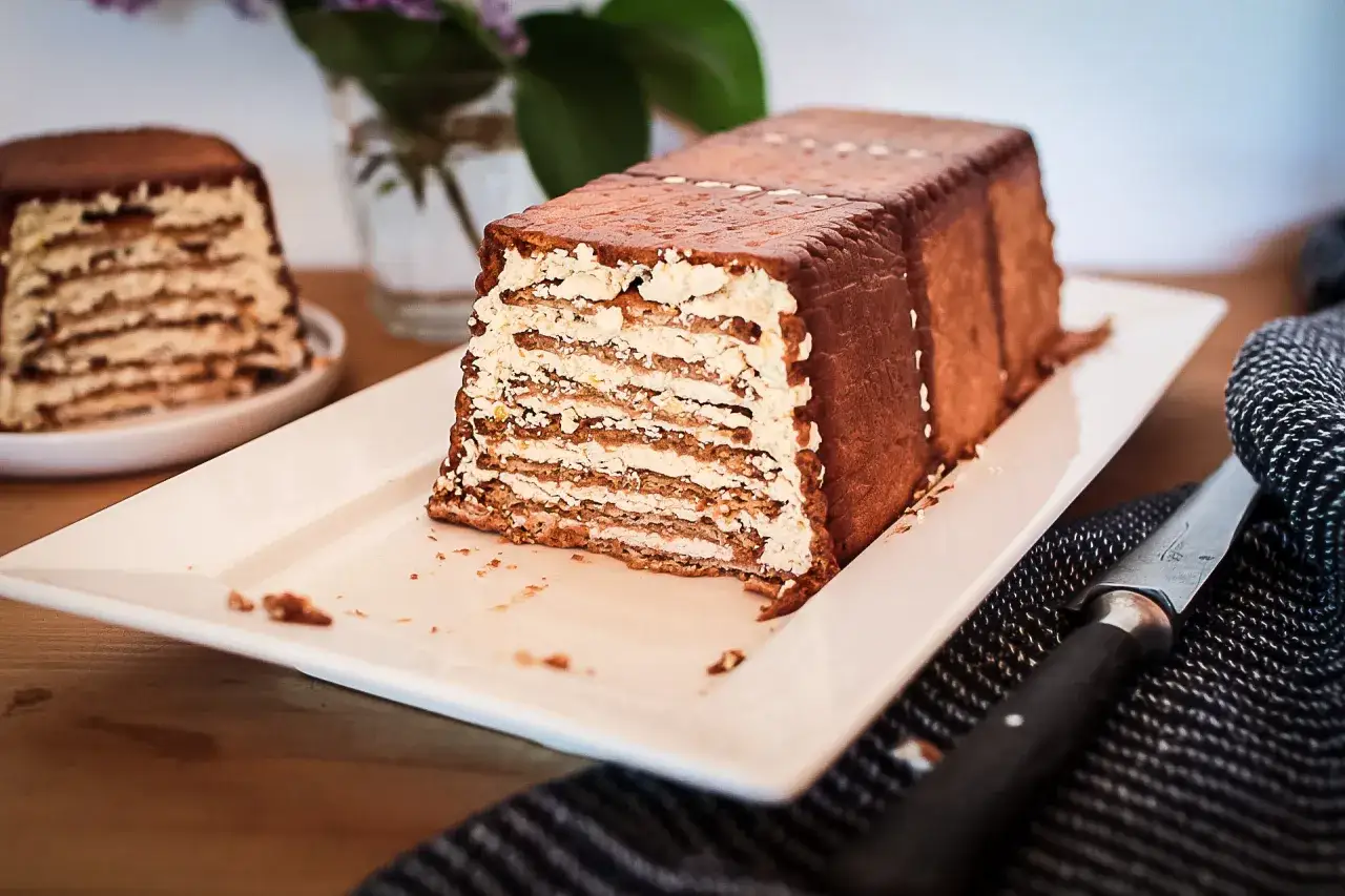 Un d&eacute;licieux g&acirc;teau biscuit, avec des couches de cr&egrave;me et de biscuits, recouvert de chocolat. Un autre g&acirc;teau similaire est visible en arri&egrave;re-plan.