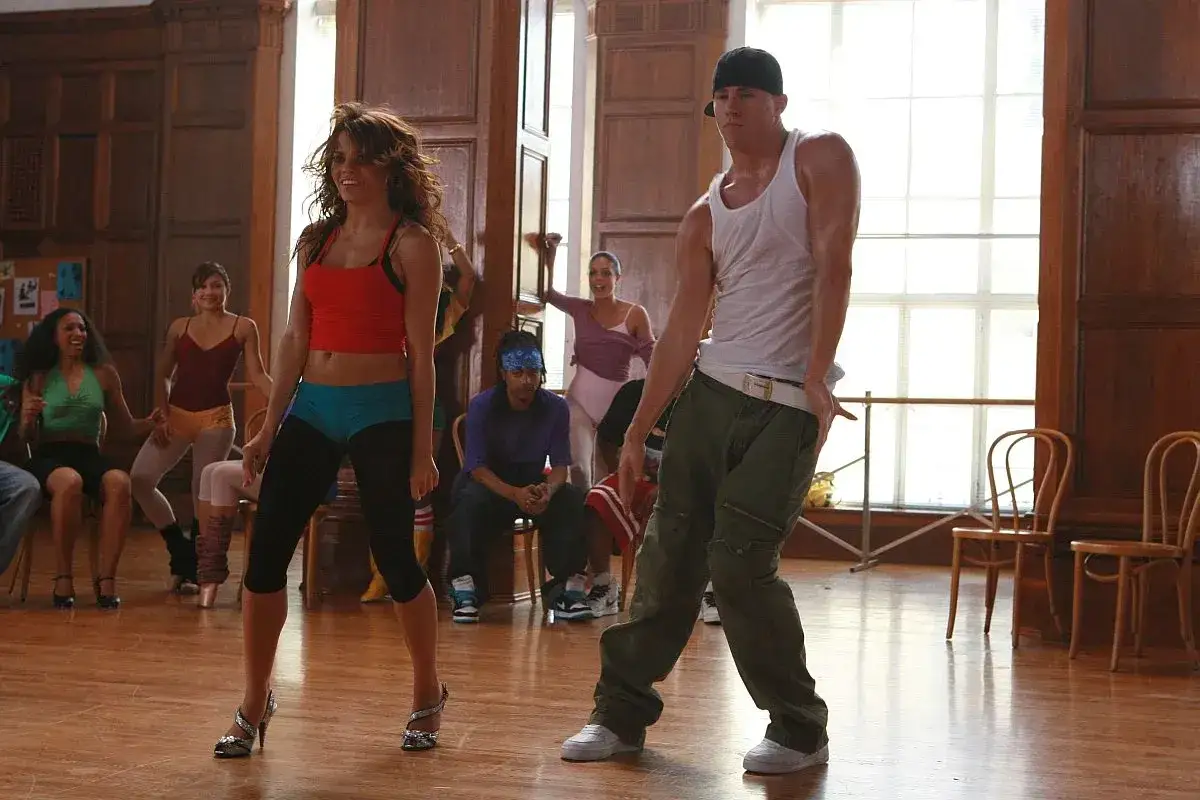 Step Up: Taniec zmysłów - obsada w akcji. Channing Tatum i Jenna Dewan w sali treningowej, otoczeni innymi tancerzami.