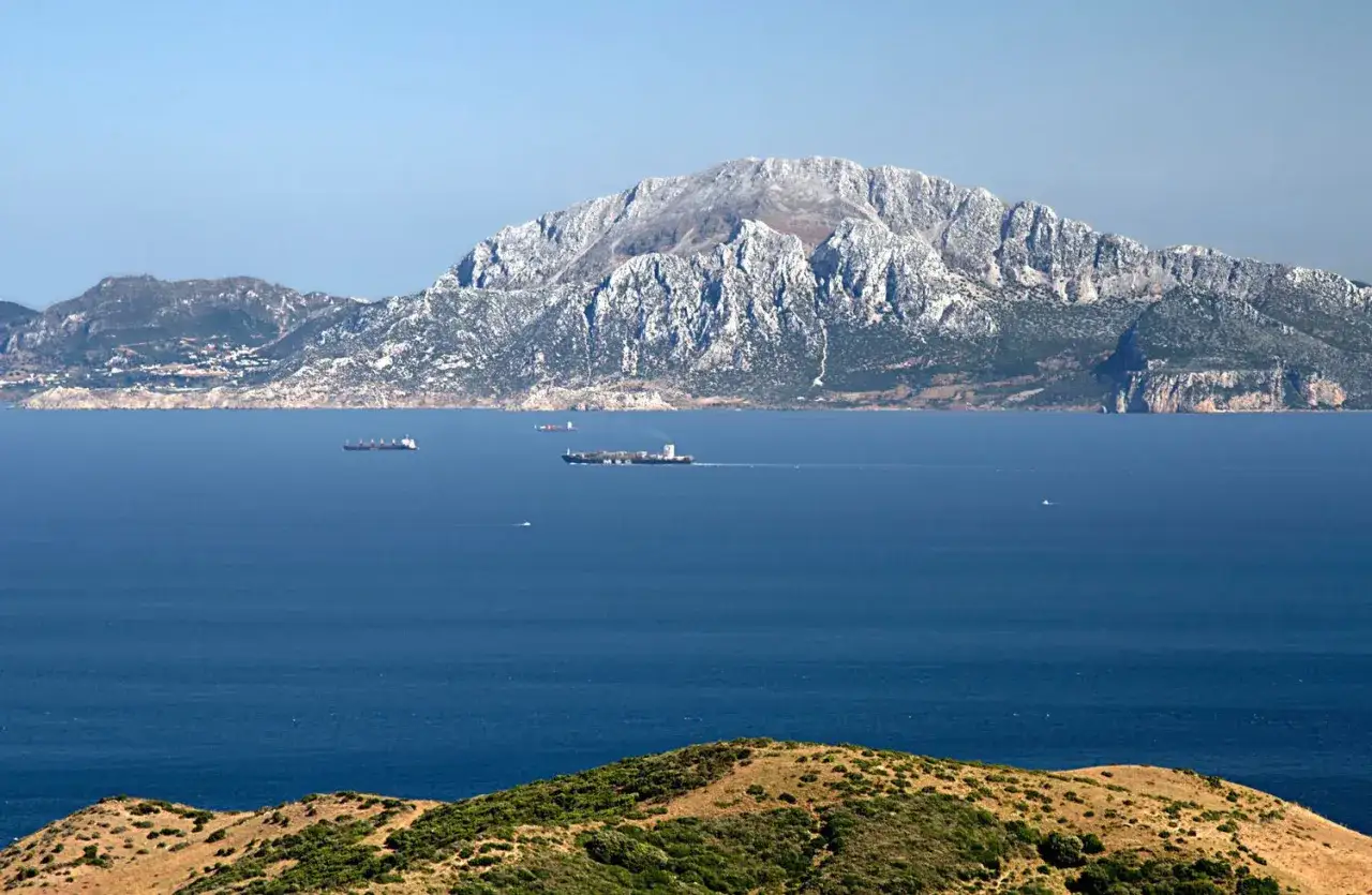 Le colonne d'Ercole oggi: imponente rocca rocciosa domina lo stretto, solcato da navi cargo.