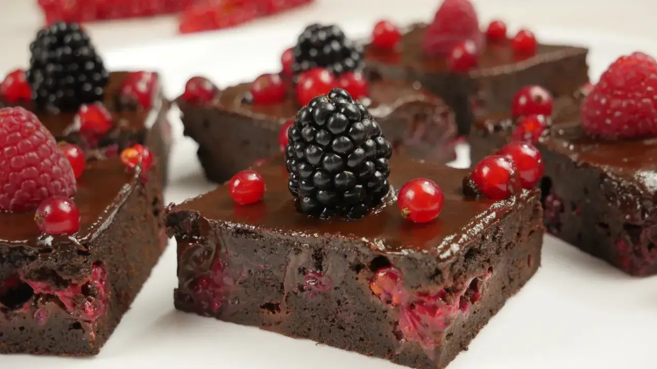 Saftige Brownies mit Beeren, ein köstliches brownie rezept ohne schokolade, garniert mit Brombeeren und Johannisbeeren.