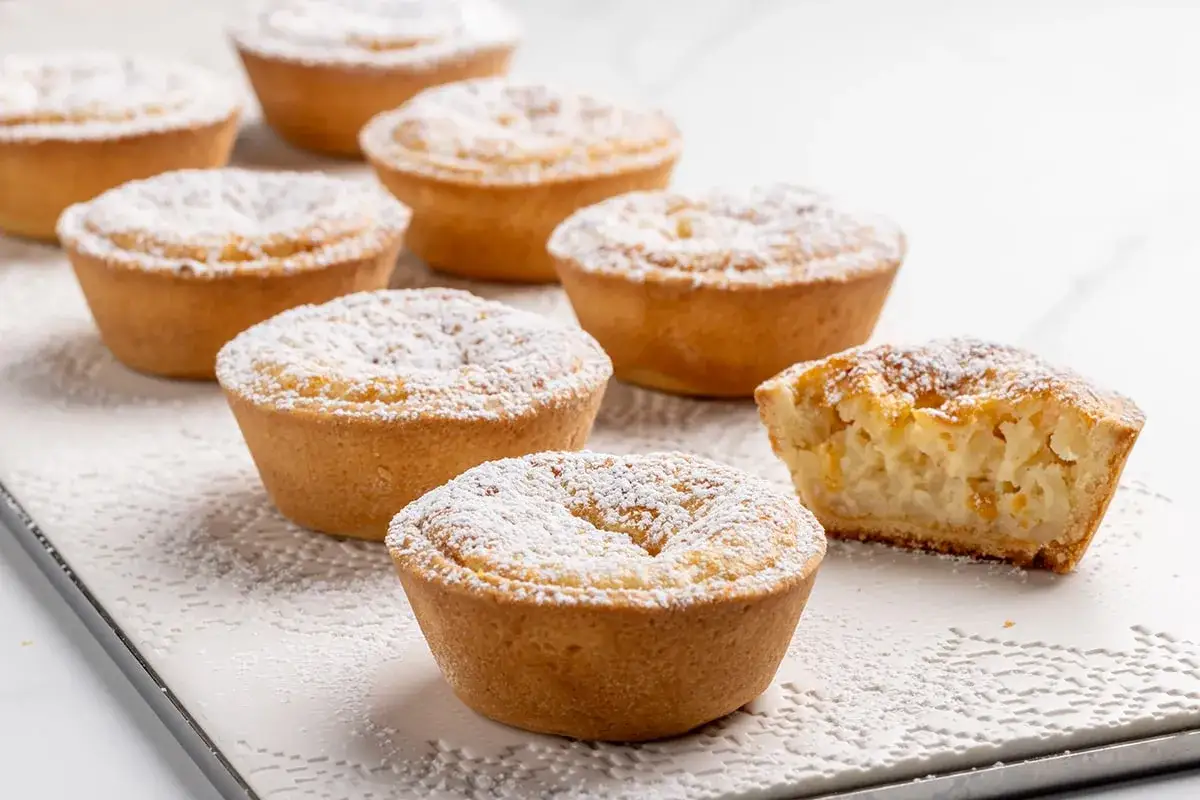 Deliziosi pasticcini con ripieno cremoso, spolverati di zucchero a velo. Un vero budino fatto in casa, perfetto per ogni occasione.