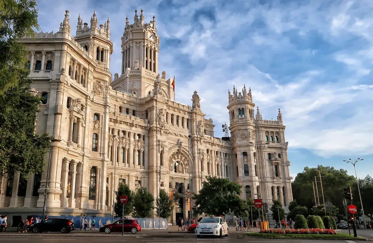 Palacio de Cibeles, un imprescindible que ver en Madrid en un día. Fachada monumental, torre con reloj y cielo azul.