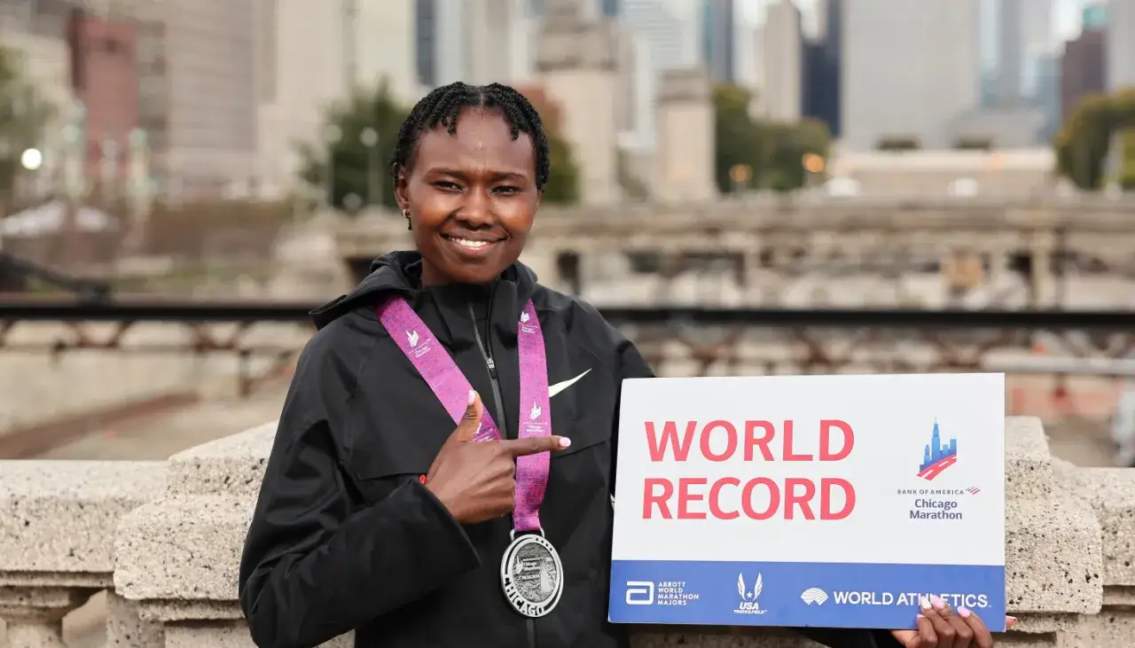Ruth Chepngetich, strahlend mit ihrer Medaille und einem Schild