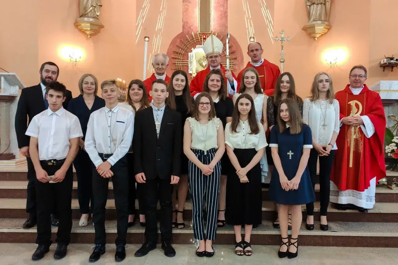 Grupa młodzieży w kościele podczas uroczystości bierzmowania. W centrum biskup w szatach liturgicznych.
