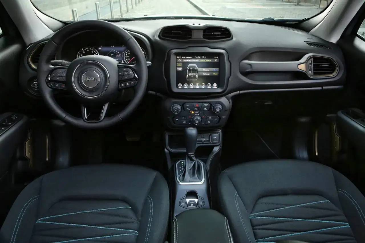 Interior del Jeep Renegade listo para una prueba de manejo. Volante, pantalla t&aacute;ctil y asientos con costuras azules.