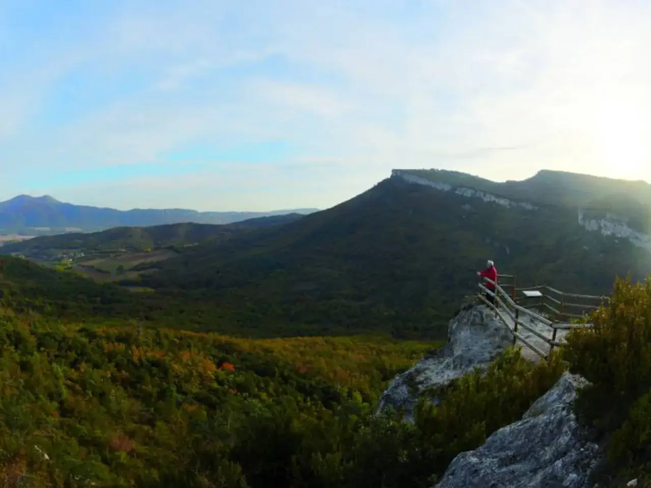 Persona contemplando el vasto paisaje de la sierra de Entzia desde un mirador.
