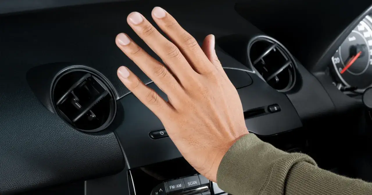 Hand testar bilens ac. Kall luft flödar ut, skönt!
