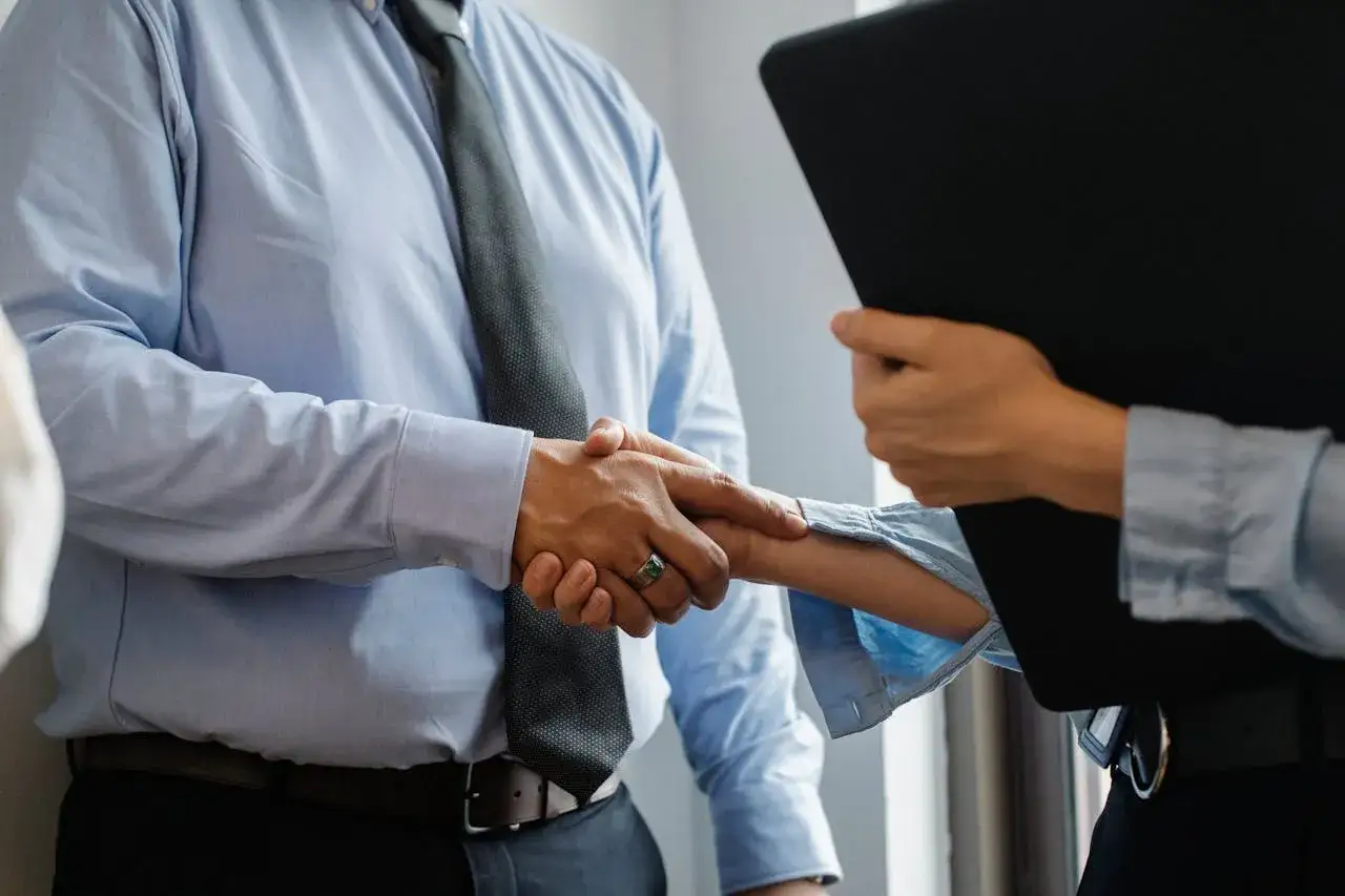 Key account manager wita klienta, ściskając dłoń.