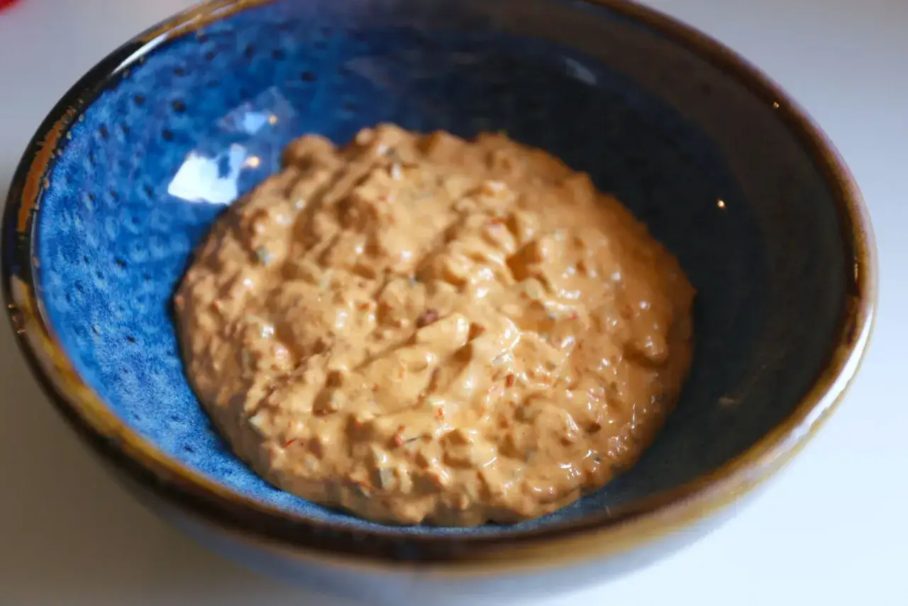 Krämig dressing i en blå skål, perfekt för ditt hamburgerdressing recept.