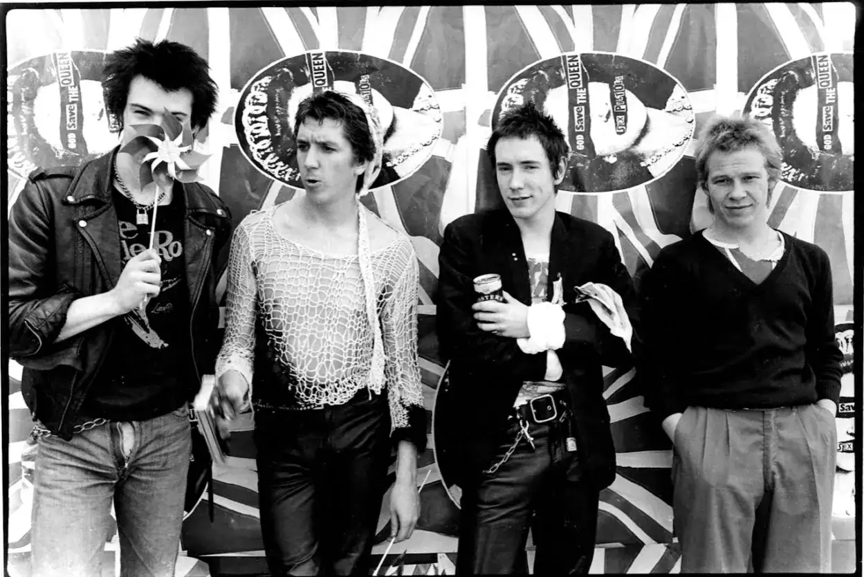 Les membres des Sex Pistols posent devant des affiches