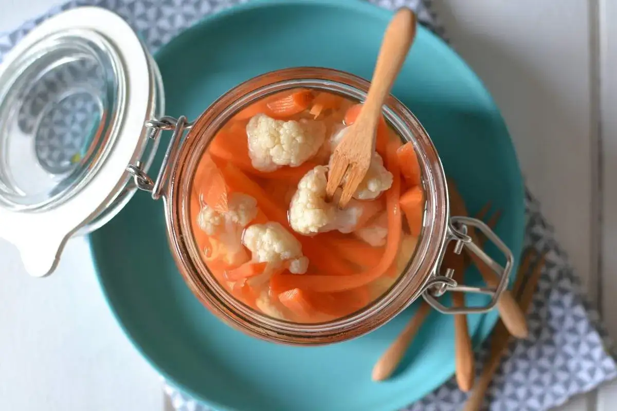 Bocal de pickles maison : carottes et chou-fleur marin&eacute;s, pr&ecirc;ts &agrave; d&eacute;guster. Une recette facile pour des l&eacute;gumes croquants.