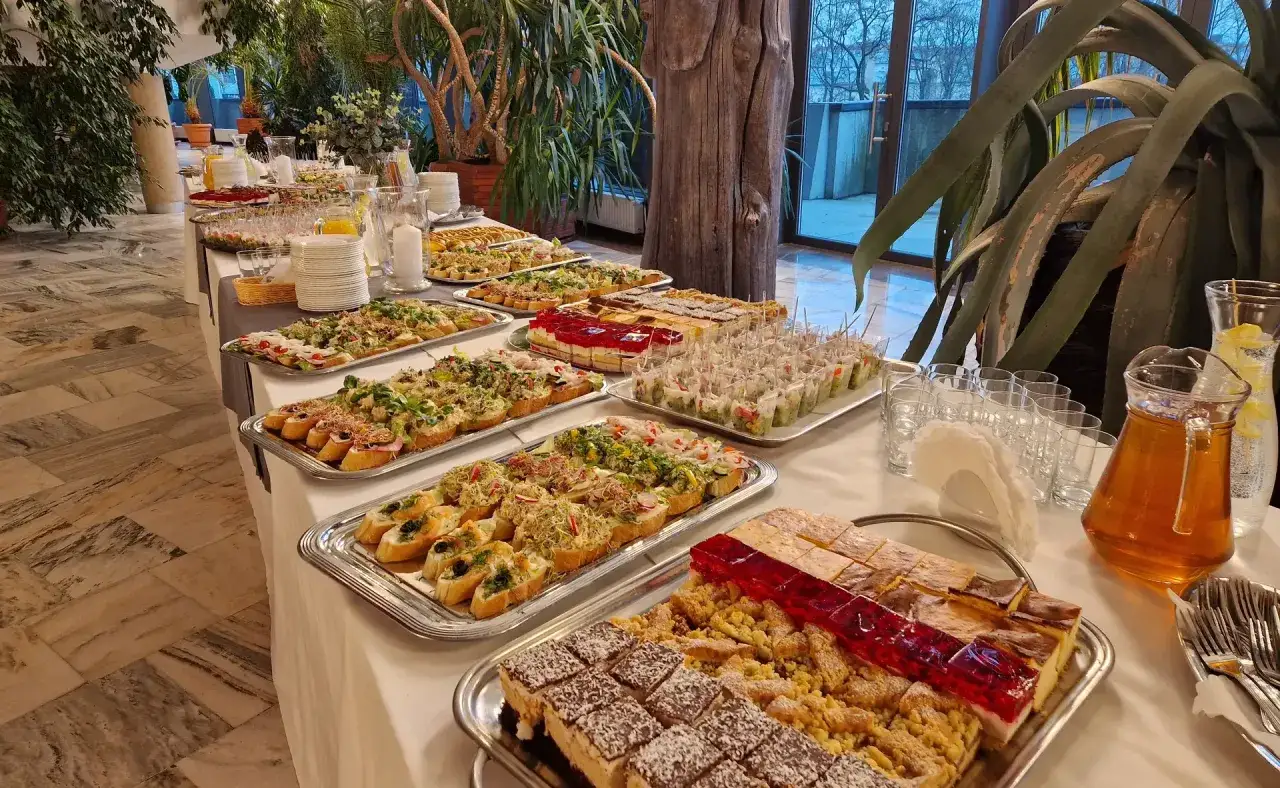 Bogaty wyb&oacute;r przekąsek i deser&oacute;w na stole. To jest właśnie catering, kt&oacute;ry zachwyca smakiem i wyglądem.