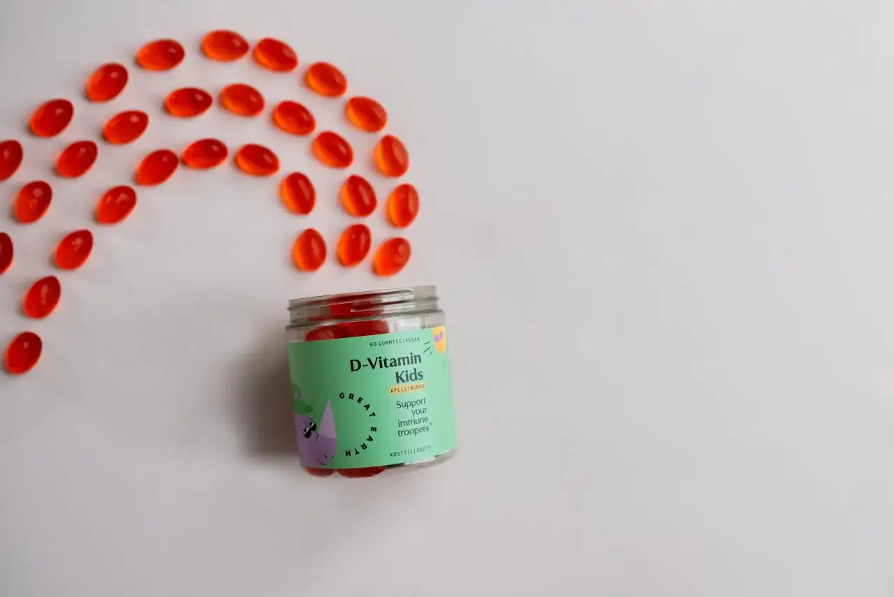 Röda D-vitamin gummies för barn ligger utspridda som en båge bredvid burken. Perfekt för små immunförsvar!