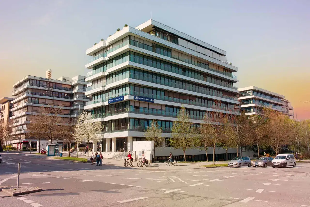 Moderne Geb&auml;ude der Munich Business School, die f&uuml;r ihre AACSB Akkreditierung bekannt ist. Menschen gehen und fahren Fahrrad.