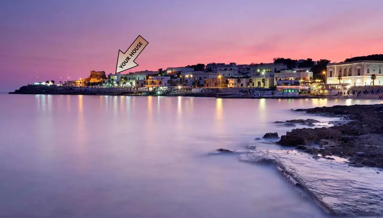 Il lungomare di Santa Maria di Leuca al tramonto, con le luci della citt&agrave; che si riflettono sul mare calmo. La tua casa &egrave; l&igrave;, in quella vista incantevole.