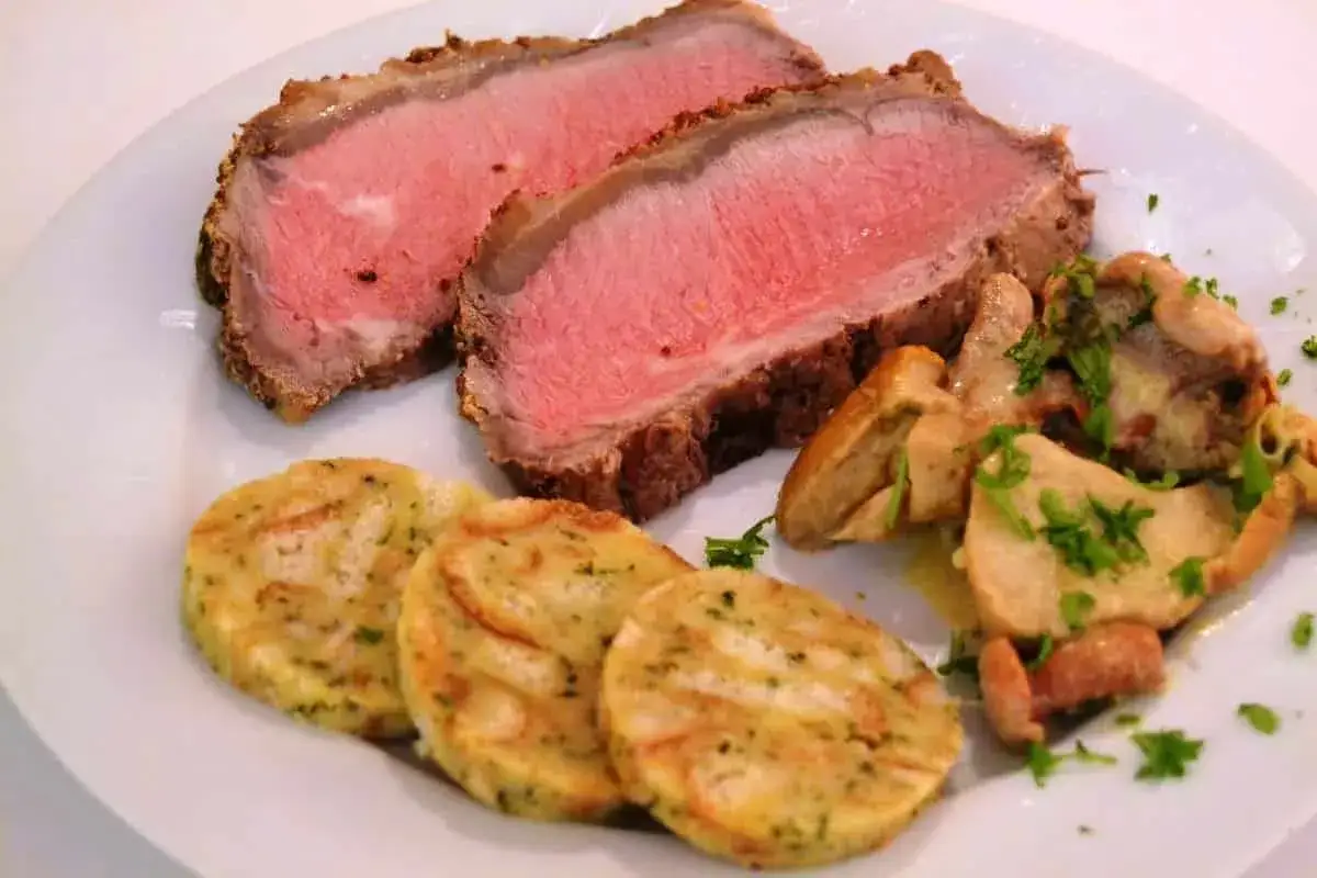 Zartes Roastbeef, perfekt rosa gebraten, serviert mit Semmelkn&ouml;deln und Pilzen. Ein klassisches Roastbeef Rezept.