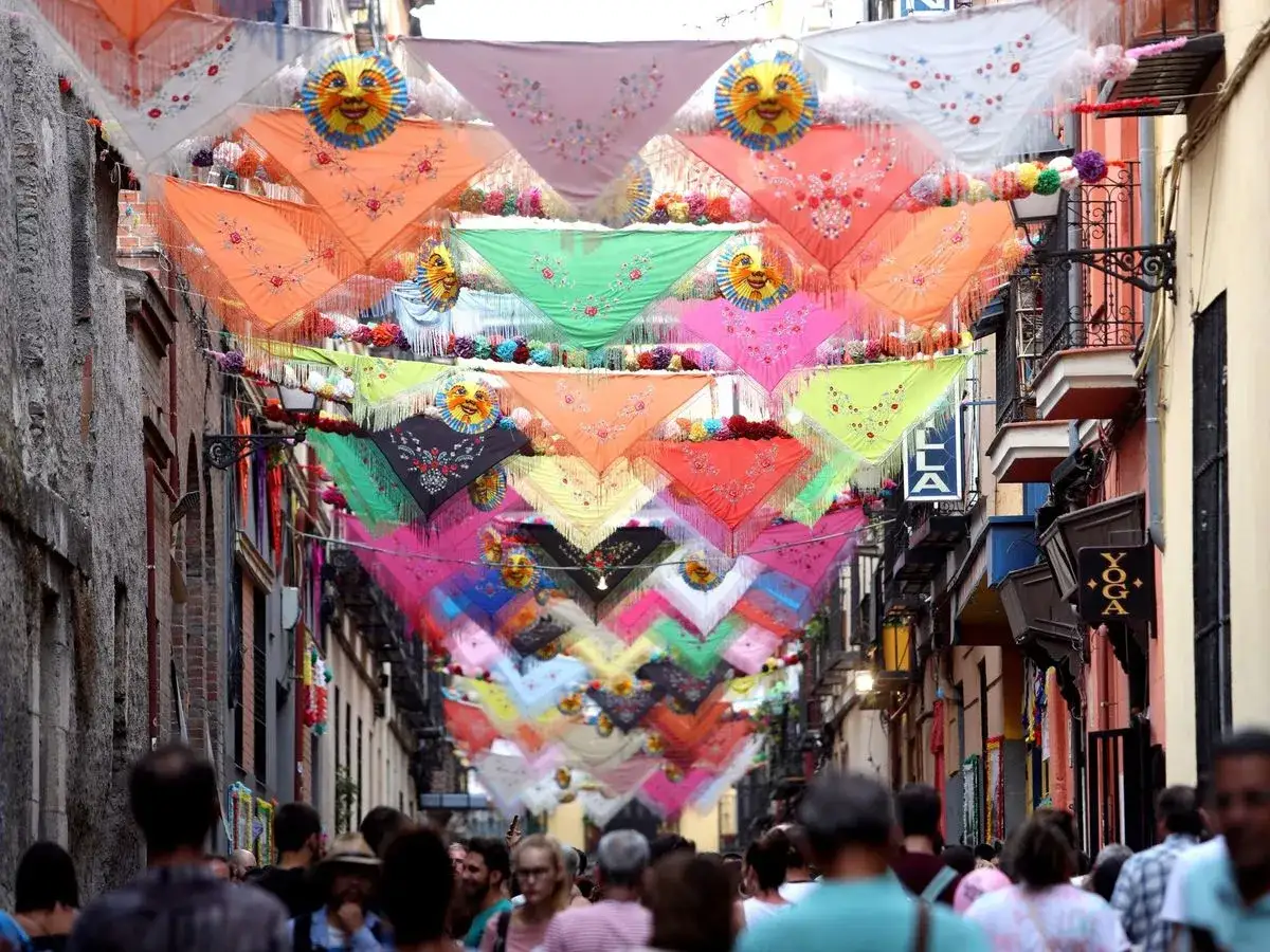 Calle engalanada con pa&ntilde;uelos de colores y soles sonrientes para las fiestas San Cayetano Madrid.