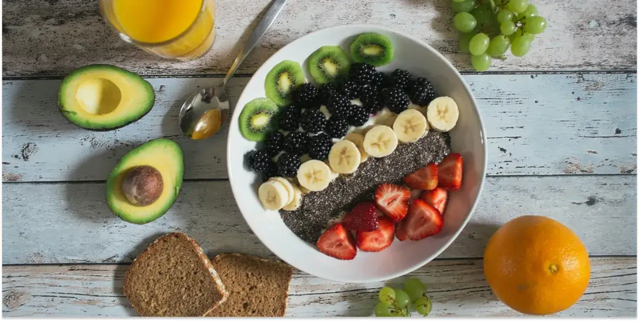 Fruchtiger Smoothie-Bowl mit Beeren, Kiwi, Banane und Chiasamen. Avocado und Orangensaft sind ebenfalls zu sehen, wo sind Elektrolyte drin?