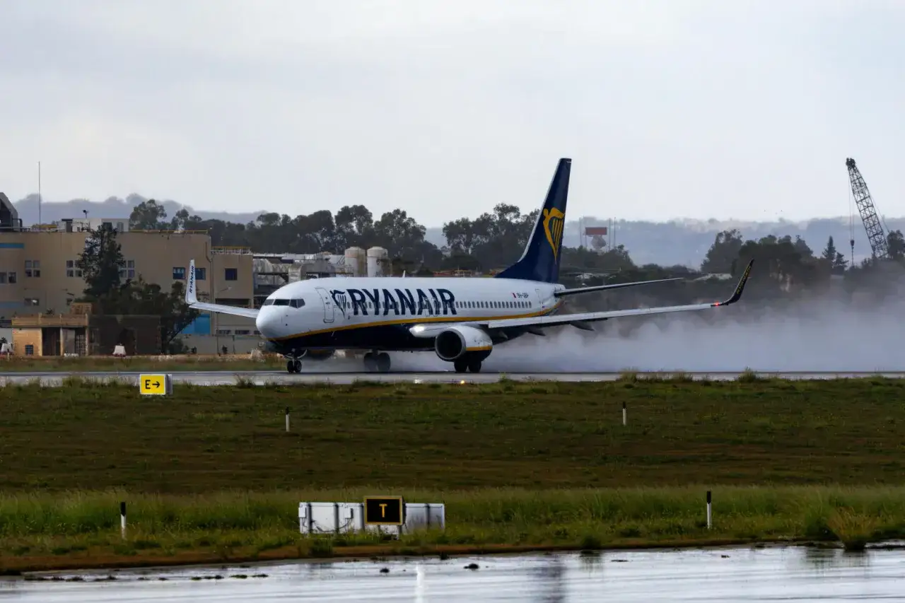 Samolot Ryanair na pasie startowym, tworząc mgiełkę wody. Zastanawiasz się, ile trwa lot z Wrocławia na Sycylię?