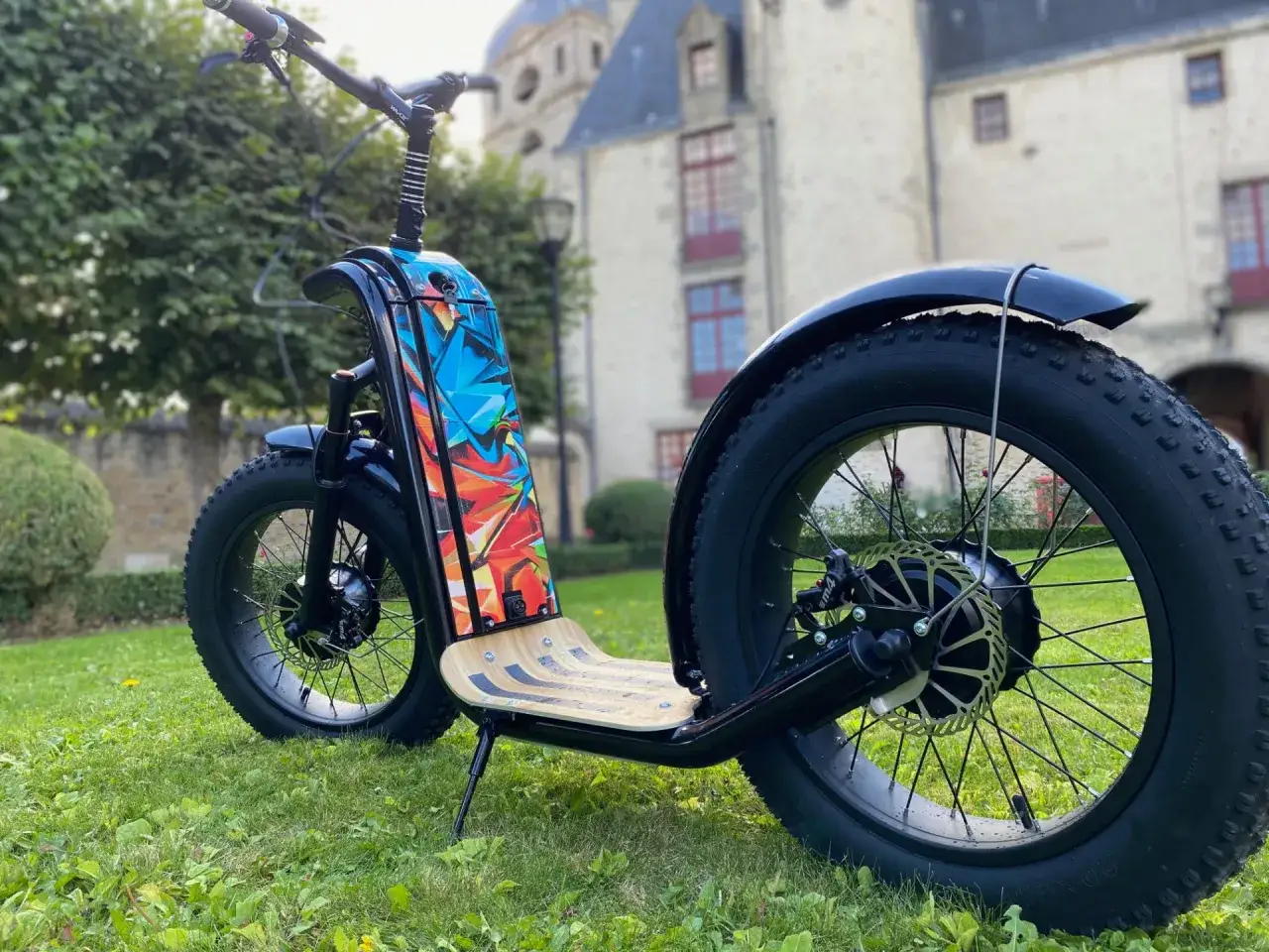 Trottinette électrique au design audacieux, avec un plateau en bois et une décoration graffiti colorée. La taille roue trottinette est imposante, prête pour l'aventure.