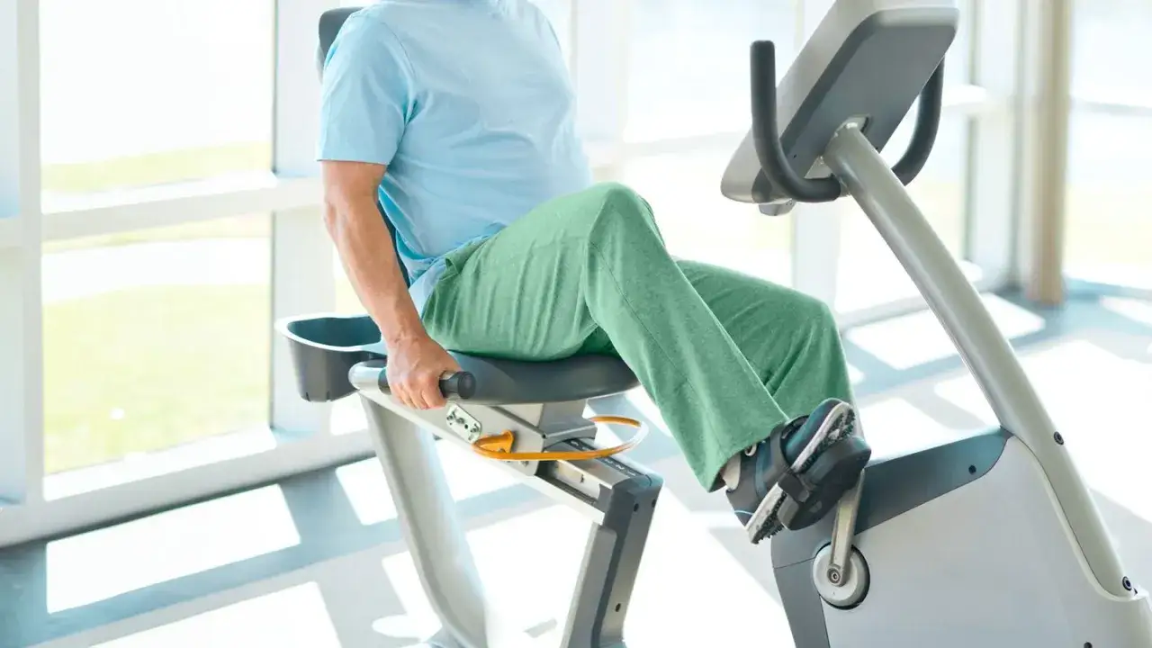 Man on recumbent bike, a gentle exercise that may help reduce knee swelling.