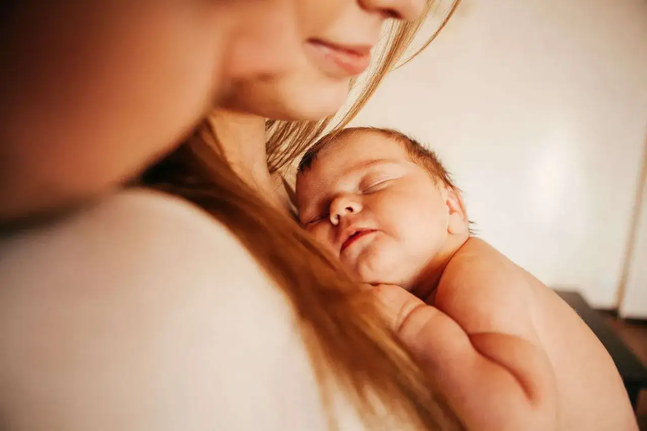Un beb&eacute; duerme pl&aacute;cidamente en brazos de su madre. A pesar de que algunos dicen que mi beb&eacute; no tiene apego conmigo, esta imagen muestra un momento de paz y conexi&oacute;n.