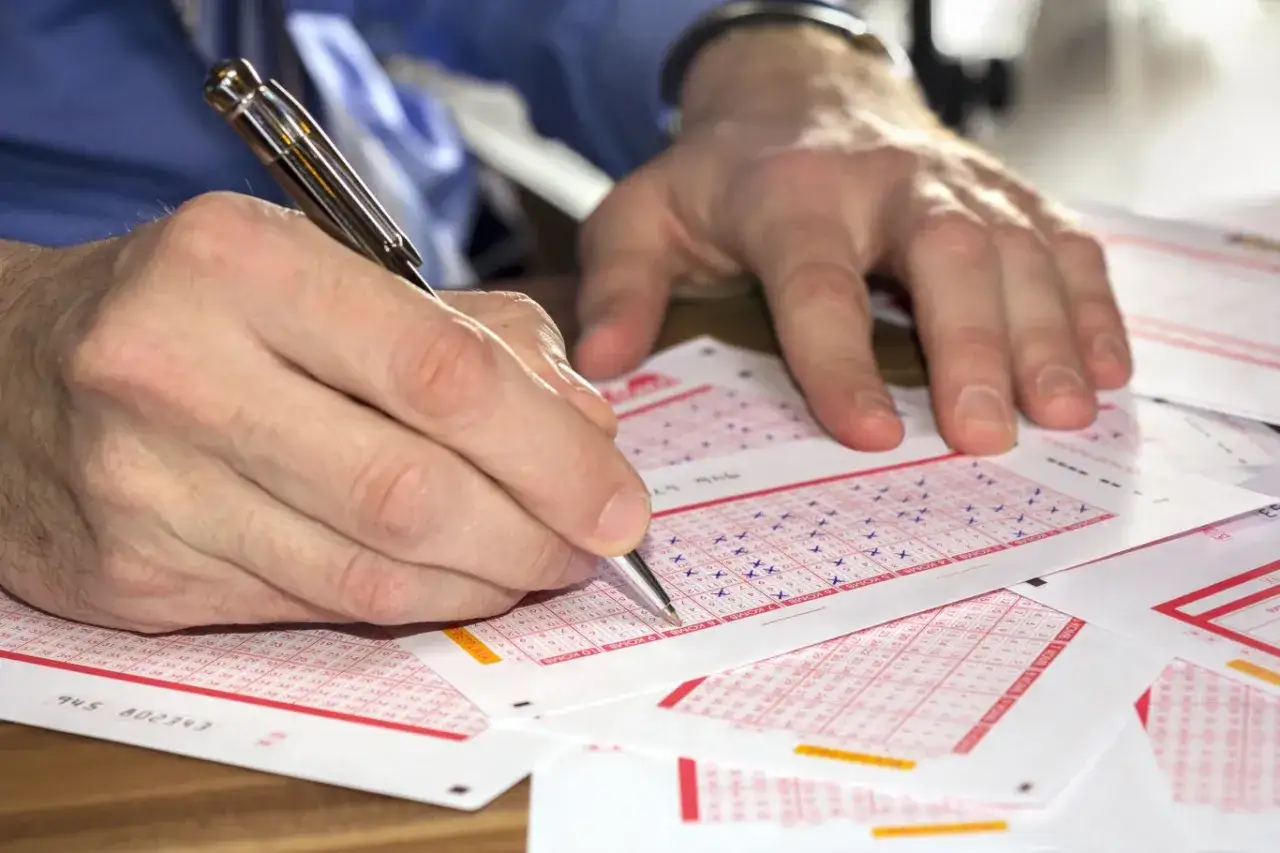 osoba zastanawiająca się nad kuponem lotto i systemami gry