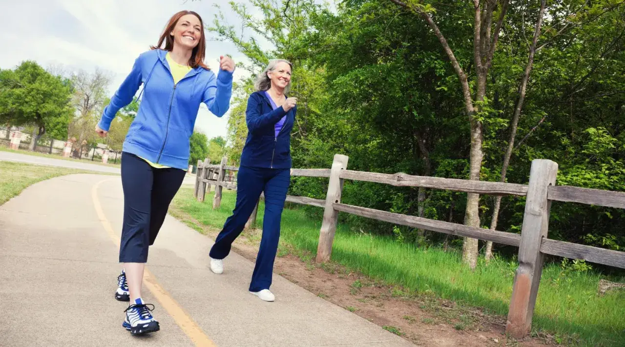Due donne corrono su un sentiero, godendosi l'aria fresca e bruciando calorie camminata.