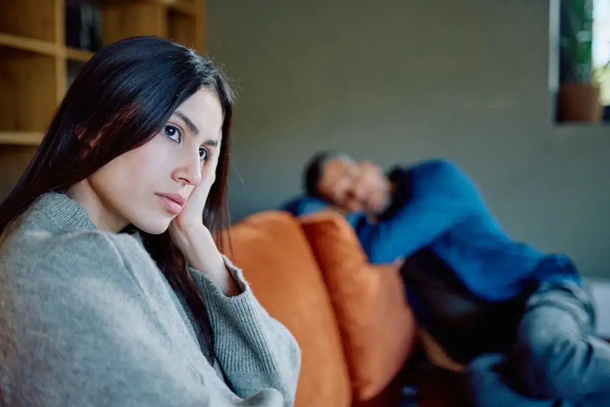 Une femme au regard triste, la main sur la joue, semble avoir dit