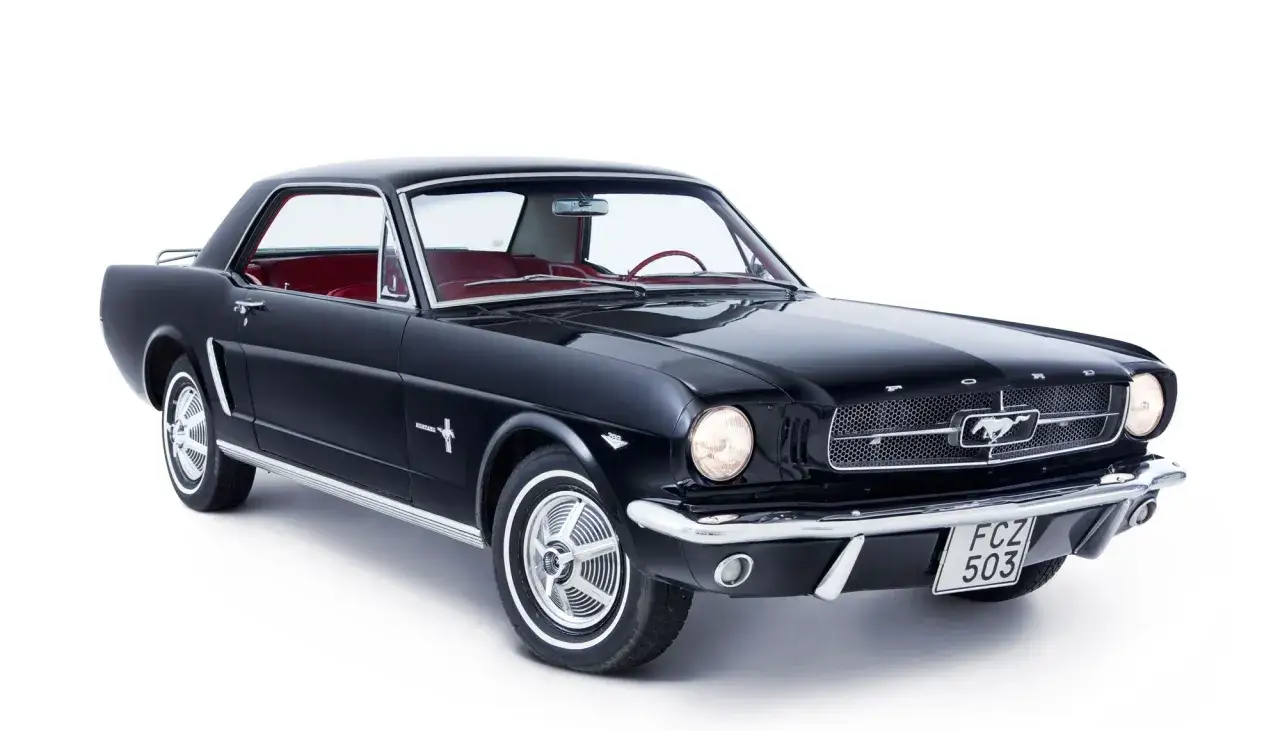 Svart klassisk mustang 60-tal med r&ouml;tt innertak, redo f&ouml;r en tur l&auml;ngs kusten.