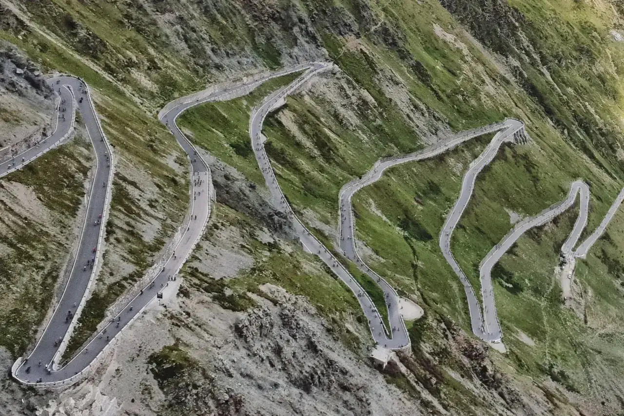Salita mozzafiato al Passo dello Stelvio in moto, con tornanti che si snodano su un pendio verdeggiante.