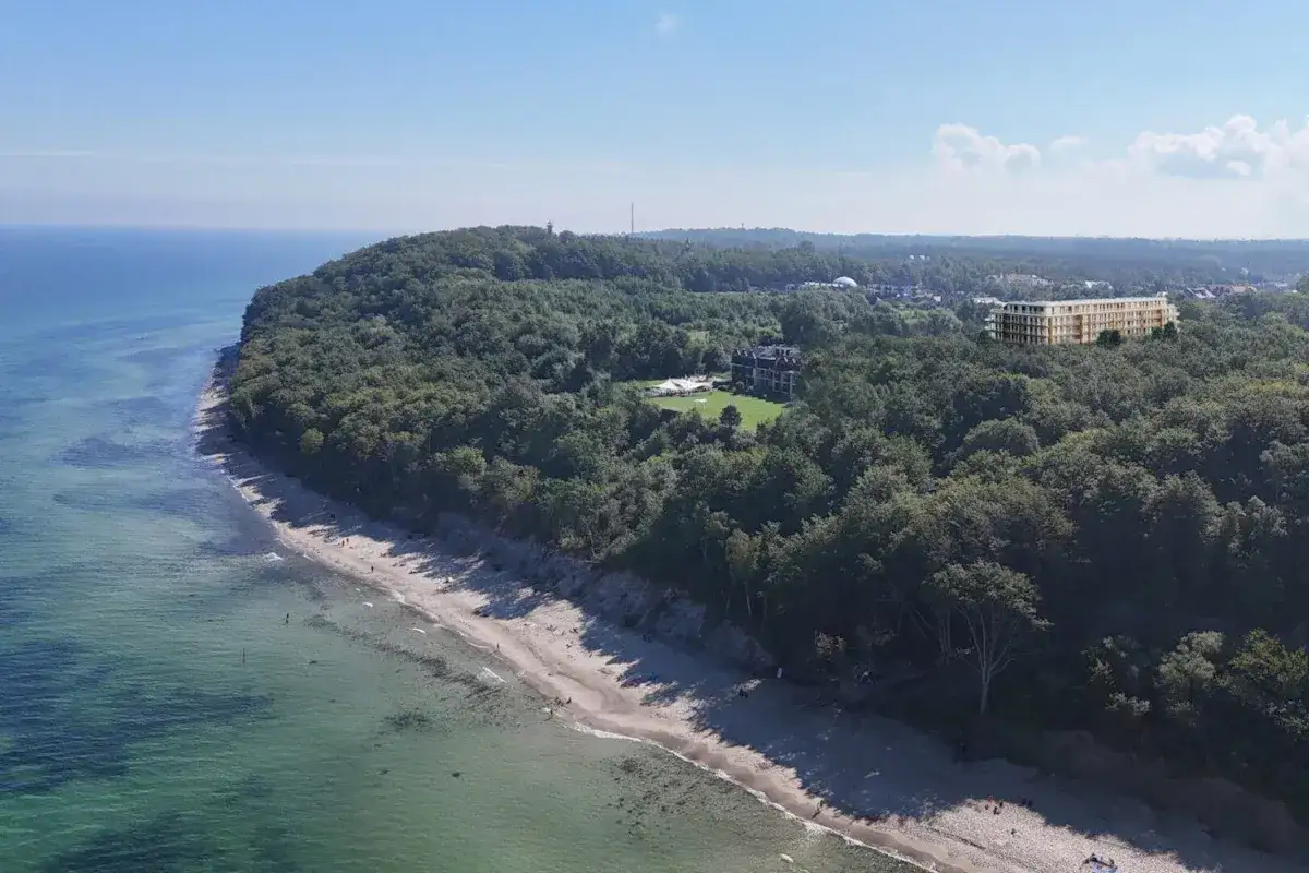 Nowoczesne apartamenty Jastrzębia Góra w otoczeniu zieleni, z widokiem na morze i plażę.