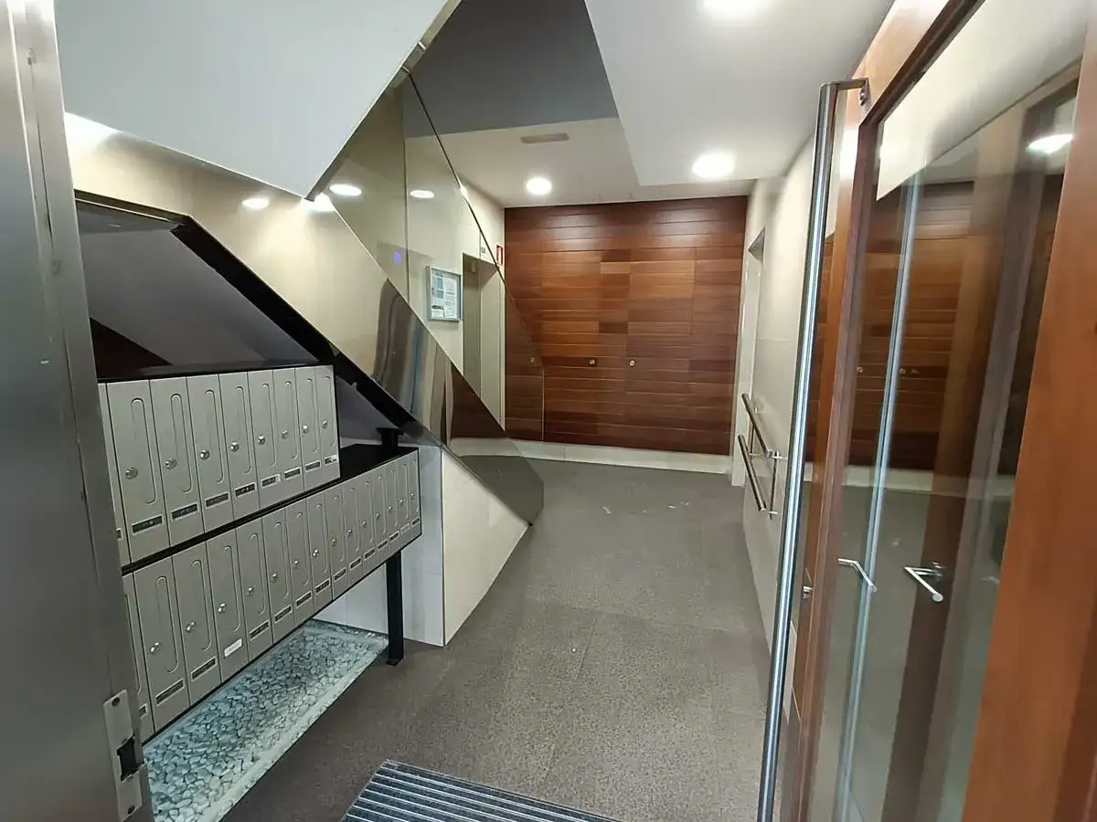 Buzones y puerta de cristal en un portal moderno. El dise&ntilde;o del espacio sugiere un buen control de acceso para la comunidad de propietarios.